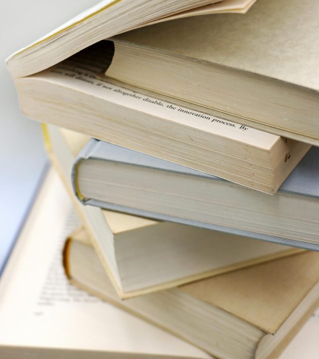 A close-up of a stack of open and closed books, perfect for learning and education themes.
