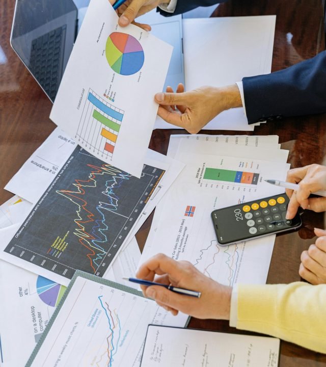 Business professionals analyzing financial charts and graphs during a meeting.